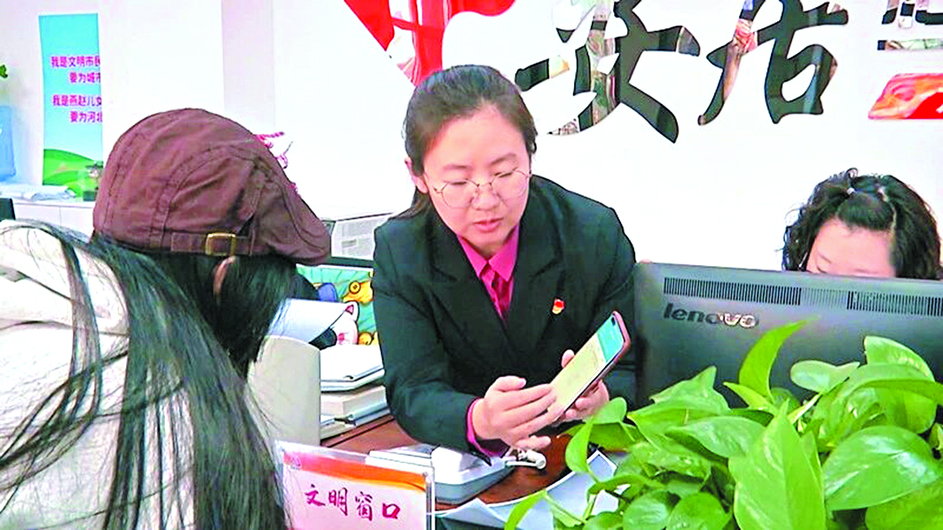 趙靜思(中)正在為居民辦理業(yè)務(wù)。(圖片由北戴河區(qū)提供)